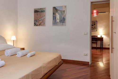 a white room with a bed and a table at Medici Chapels Apartment in Florence