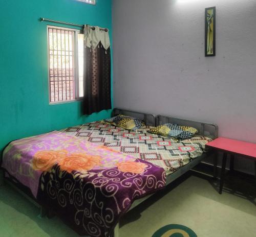 プリーにあるJHARANA GUEST HOUSEのベッドルーム1室(カラフルな掛け布団付きのベッド1台付)