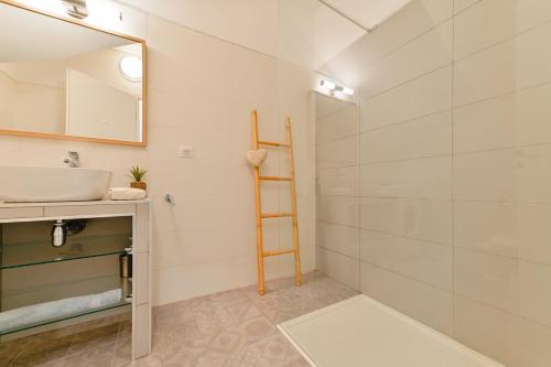 une salle de bain avec un lavabo et un miroir dans l'établissement Charmant Appartement - Jardinet Privé - 5 minutes des plages Sanguinaires - Ajaccio, à Ajaccio