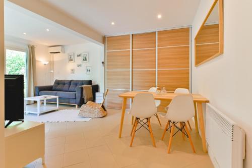 une cuisine et un salon avec une table et des chaises dans l'établissement Charmant Appartement - Jardinet Privé - 5 minutes des plages Sanguinaires - Ajaccio, à Ajaccio