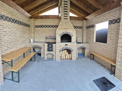 an outdoor patio with a brick fireplace and benches at Vila Tudor in Borşa