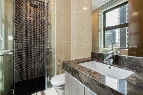 La salle de bains est pourvue d'un lavabo, de toilettes et d'une fenêtre. dans l'établissement D'Rapport Residences by Nexus Homes, à Kuala Lumpur