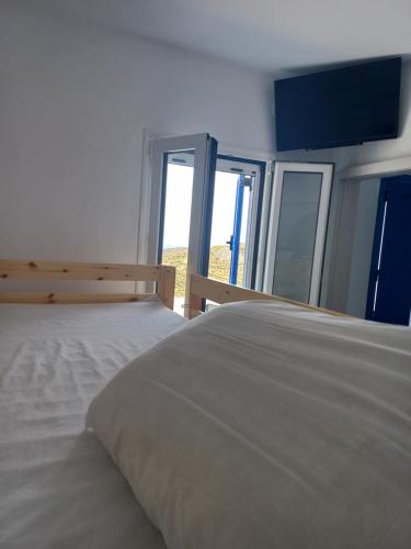 1 dormitorio con 2 camas y ventana grande en Relax, en Pírgos