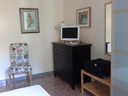 um quarto com um computador numa cómoda com uma cadeira em Maison Di Biancaneve em Roma