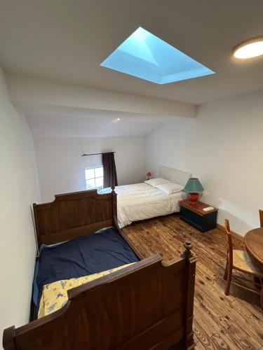 une chambre avec un lit et une lucarne dans l'établissement Le grenier de la place d'Isly, à Verdun-sur-Meuse