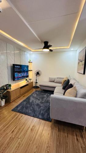 un soggiorno con divano e TV a schermo piatto di ECO Staycation - En Casa Orila a Manila