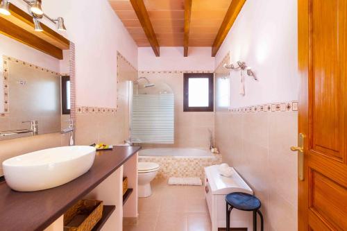 ein Badezimmer mit einem Waschbecken, einem WC und einer Badewanne in der Unterkunft Sa caseta in Artá