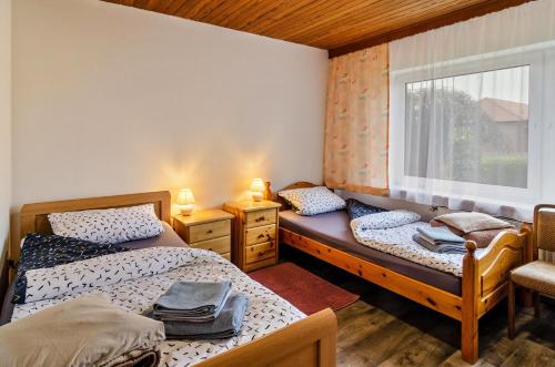 zwei Einzelbetten in einem Zimmer mit Fenster in der Unterkunft Haus Störtebeker in Marienhafe