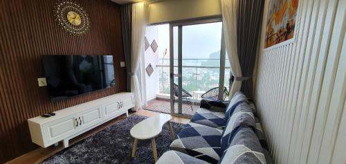 uma sala de estar com um sofá e uma televisão em Căn hộ shaphire hongai em Ha Long