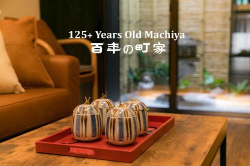 a group of five silver dishes on a red tray on a table at Nishodo Machiya HIKARU GOJO in Kyoto