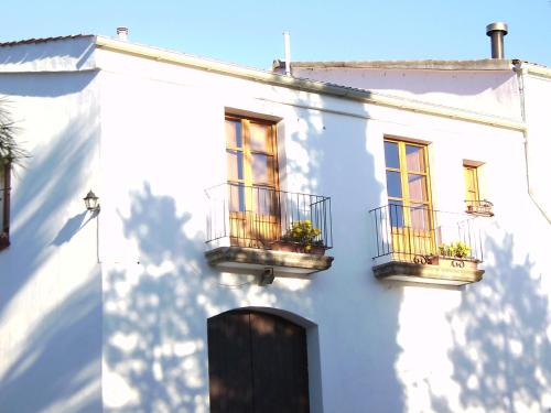 ein weißes Gebäude mit zwei Balkonen und zwei Fenstern in der Unterkunft Luxurious Cottage in Sant Salvador de Guardiola in Guardiola