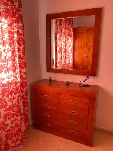 a dresser with a mirror on top of it at Carolina apartamento de Luxe in Mazarrón