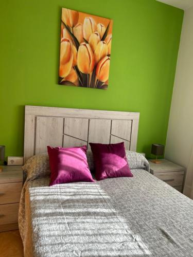a bedroom with a bed with purple pillows and a painting at Carolina apartamento de Luxe in Mazarrón