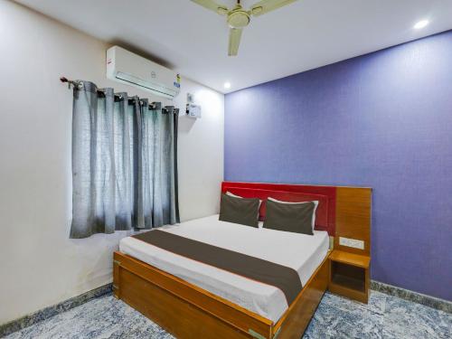 um quarto com uma cama com uma parede vermelha e azul em Collection O elegant residency em Chennai