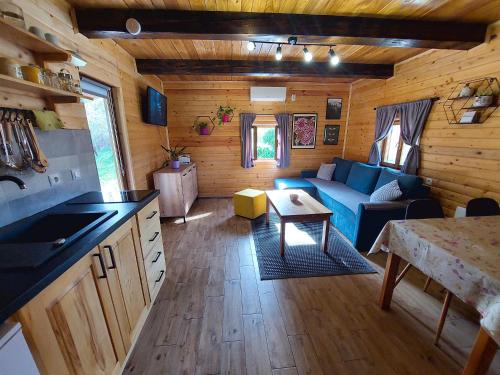 a living room with a blue couch in a cabin at Holiday home The Hive in Slunj