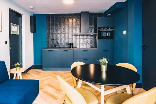 a kitchen with blue walls and a table and chairs at LVM Stays in The Hague