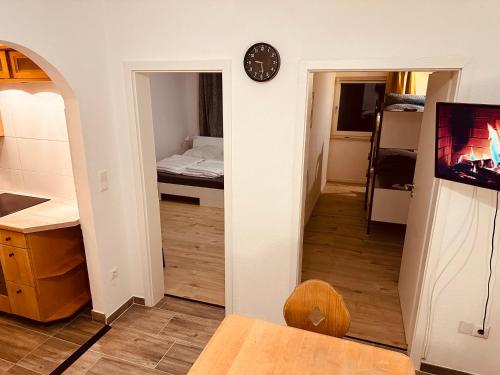 un couloir avec une chambre avec un lit et une horloge dans l'établissement FELIX LIVING 8, modern & cozy, 3 Zimmer, Balkon, Parkplatz, à Salzweg