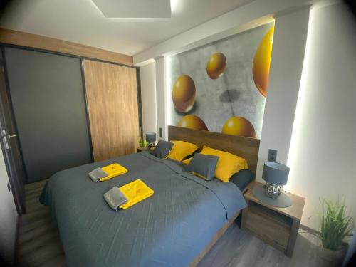 a bedroom with a blue bed with yellow pillows at Pegazus Apartman in Keszthely