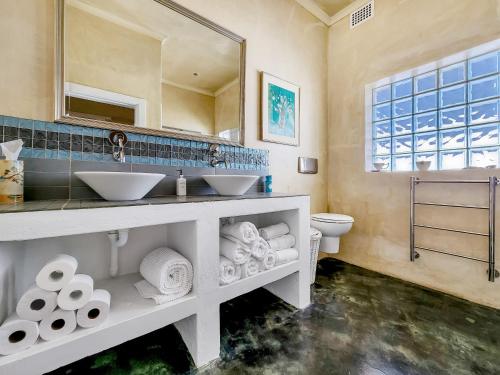 baño con 2 lavabos, espejo y aseo en Charming Family Home, en Ciudad del Cabo