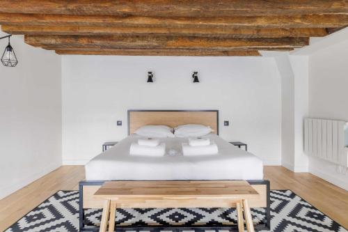 ein Schlafzimmer mit einem Bett und einer Holzdecke in der Unterkunft Parisian duplex cocoon in Saint-Germain-Des-Pres in Paris