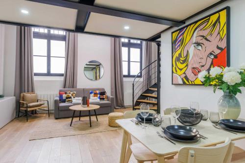 ein Wohnzimmer mit einem Tisch und einem Sofa in der Unterkunft Parisian duplex cocoon in Saint-Germain-Des-Pres in Paris