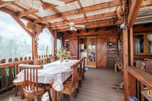 une salle à manger avec une table et des chaises sur une terrasse dans l'établissement Le Chalet Boisé - Maison avec jardin clôturé, à Montoldre
