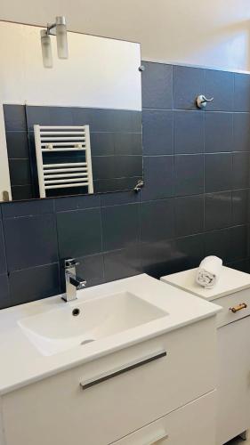 une salle de bain avec un lavabo blanc et un miroir dans l'établissement Bonne Surprise, T3 terrasse pr. plage/ centre/gare, à Arcachon