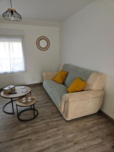 un salon avec un canapé et deux tables dans l'établissement Chez Ernestine, à Nanteuil-lès-Meaux