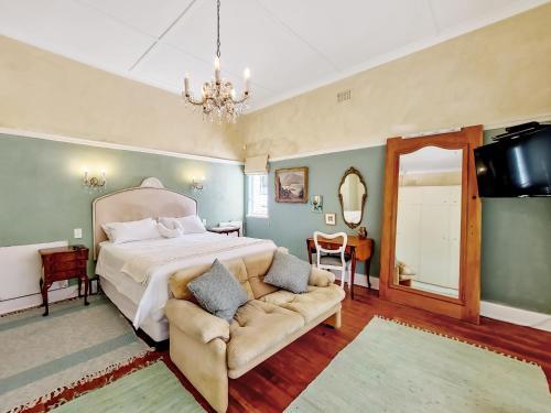 1 dormitorio con cama, sofá y lámpara de araña en Charming Family Home, en Ciudad del Cabo