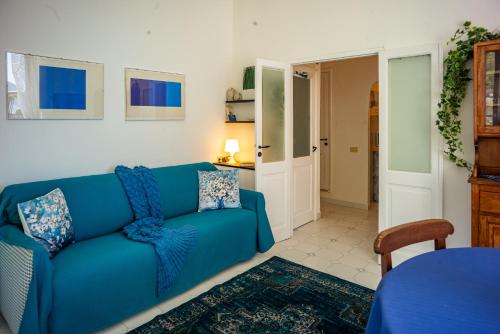 a living room with a blue couch and a table at Maemuna Sea View in Vernazza