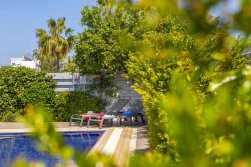 un patio con mesa y sillas junto a una piscina en Azure Luxury Pool Villa en Protaras