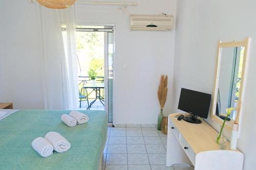 Schlafzimmer mit einem Bett und einem Schreibtisch mit einem TV in der Unterkunft Kapougiati Studios in Region Ilia