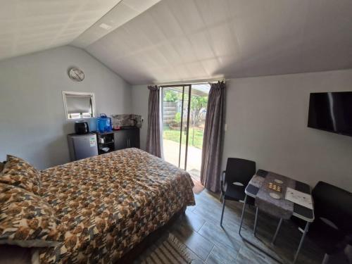 a bedroom with a bed and a tv and a window at Vosloo's rest in Vereeniging