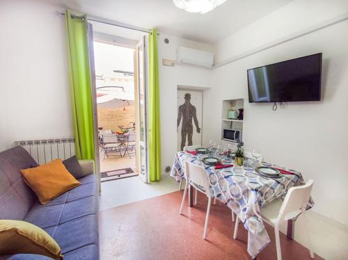 Una sala de estar con una mesa, un sofá y un televisor. en Casa Chiara in centro con corte privata, en San Benedetto del Tronto