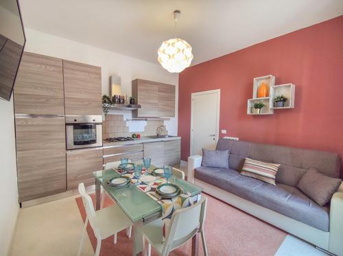Una sala de estar con un sofá y una mesa con sillas. en Casa Chiara in centro con corte privata, en San Benedetto del Tronto
