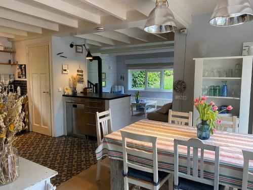 a kitchen and dining room with a table and chairs at Charmant vakantiehuis op unieke locatie in Groede