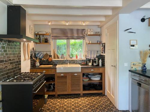 a kitchen with a sink and a stove at Charmant vakantiehuis op unieke locatie in Groede