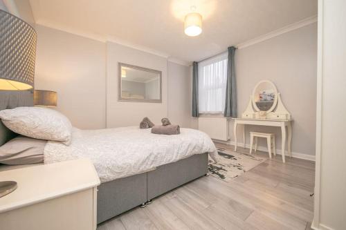 a bedroom with a large bed and a table at Beautiful Victorian Apartment in Clacton-on-Sea