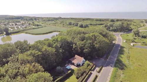 an aerial view of a house next to a river at Charmant vakantiehuis op unieke locatie in Groede