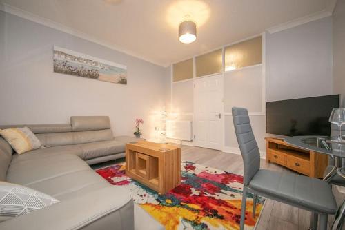 a living room with a couch and a tv at Beautiful Ground Floor Victorian Apartment in Clacton-on-Sea