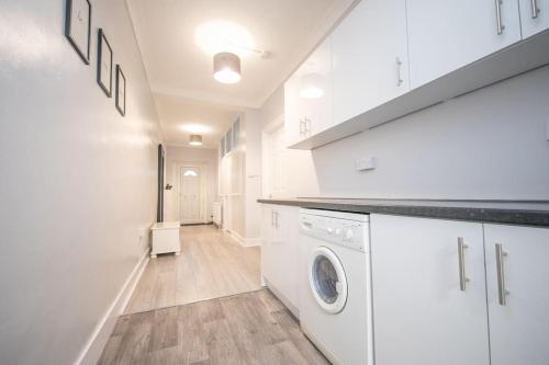 a white laundry room with a washer and dryer at Beautiful Ground Floor Victorian Apartment in Clacton-on-Sea
