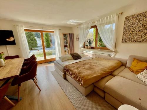ein Schlafzimmer mit einem Bett, einem Schreibtisch und einem Sofa in der Unterkunft Alpentraum am Barmsee mit Garten in Krün