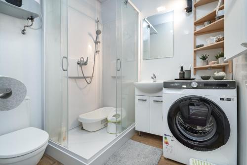 a bathroom with a washing machine and a sink at Domek wczasowy z dostępem do Mini zoo Donkeyszot 