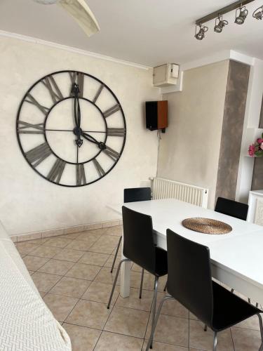 une salle à manger avec une grande horloge murale dans l'établissement Appartement tout confort, à Bourges