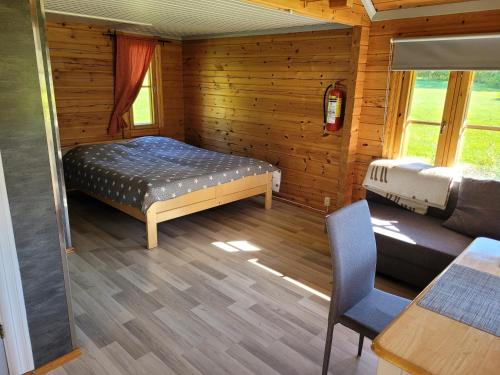 ein Schlafzimmer mit einem Bett und einem Sofa in einer Hütte in der Unterkunft Päiväkulma in Naantali