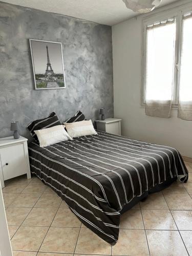- une chambre avec un grand lit et la tour Eiffel dans l'établissement Appartement tout confort, à Bourges