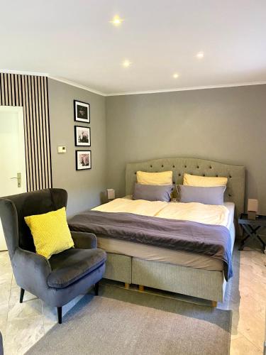a bedroom with a large bed and a chair at Bungalow Saaletal in Kahla