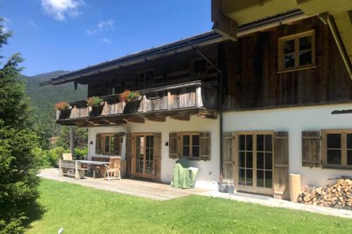 a house with a picnic table in front of it at Landhaus Riedlern - Exklusives Ferienhaus in Kreuth am Tegernsee in Kreuth