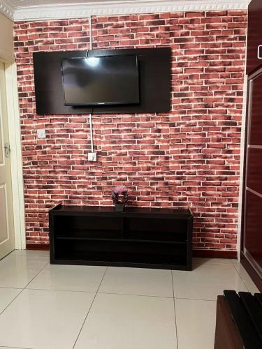 uma parede de tijolos com uma televisão de ecrã plano em Keeme-Nao Hotel em Mahalapye
