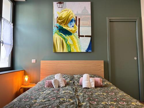 a bedroom with a bed with two pillows and a painting at Antica Stazione in Guebwiller